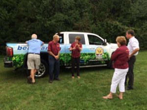 A group of people standing in front of a truck.