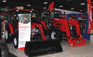 A red tractor is on display at a trade show.