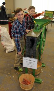 Two boys standing in front of a corn mill.