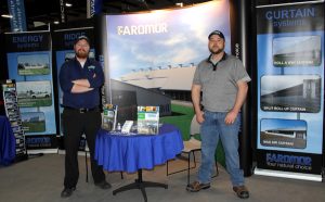 Two men standing in front of a booth at a trade show.