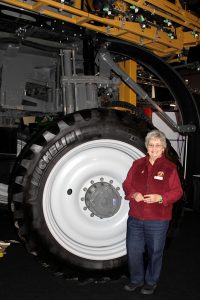 A woman standing next to a tractor.