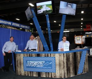 Three men standing in front of a booth.