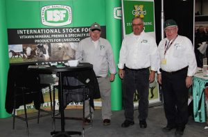 Three men standing in front of a booth.