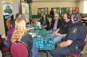 A group of people sitting around a table at a convention.