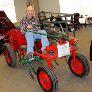 A man sitting on a red and green tractor.