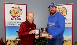 A man holding a trophy and another man standing next to him.