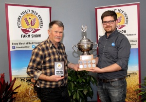 Two men holding a trophy and some cards