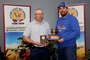 Two men holding a trophy and a plaque