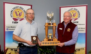 Two men holding a trophy and plaque