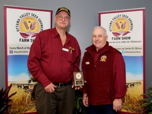 Two men standing next to each other holding a plaque.