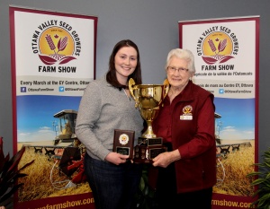 Two women holding a trophy and smiling for the camera.