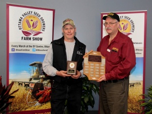 Two men holding a plaque and a trophy.