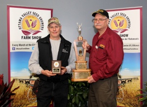 Two men holding a trophy and posing for the camera.