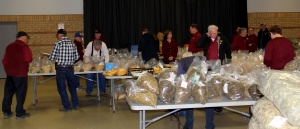 A group of people standing around tables filled with food.