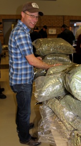 A man standing next to stacks of marijuana bags.