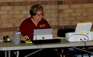 A woman sitting at a table with a laptop.