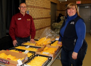 Two people standing next to a table filled with boxes of cheese.