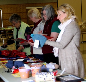 A group of women standing around a table.