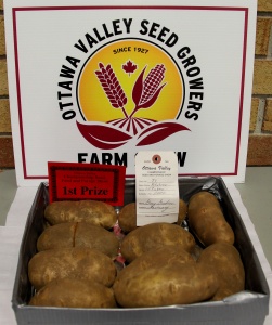 A box of potatoes with a price sign on top.