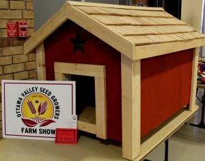 A red and white dog house with a sign