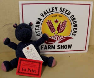 A stuffed animal sitting next to a sign.