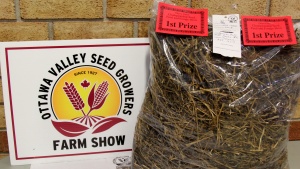 A bag of hay and a sign for the valley seed growers farm show.