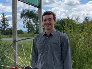 A man standing in front of some bushes