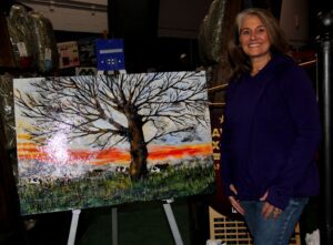 A woman standing next to an art work.