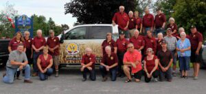 A group of people standing in front of a truck.