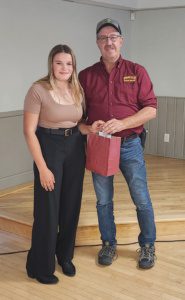 Woman and man holding award at event.